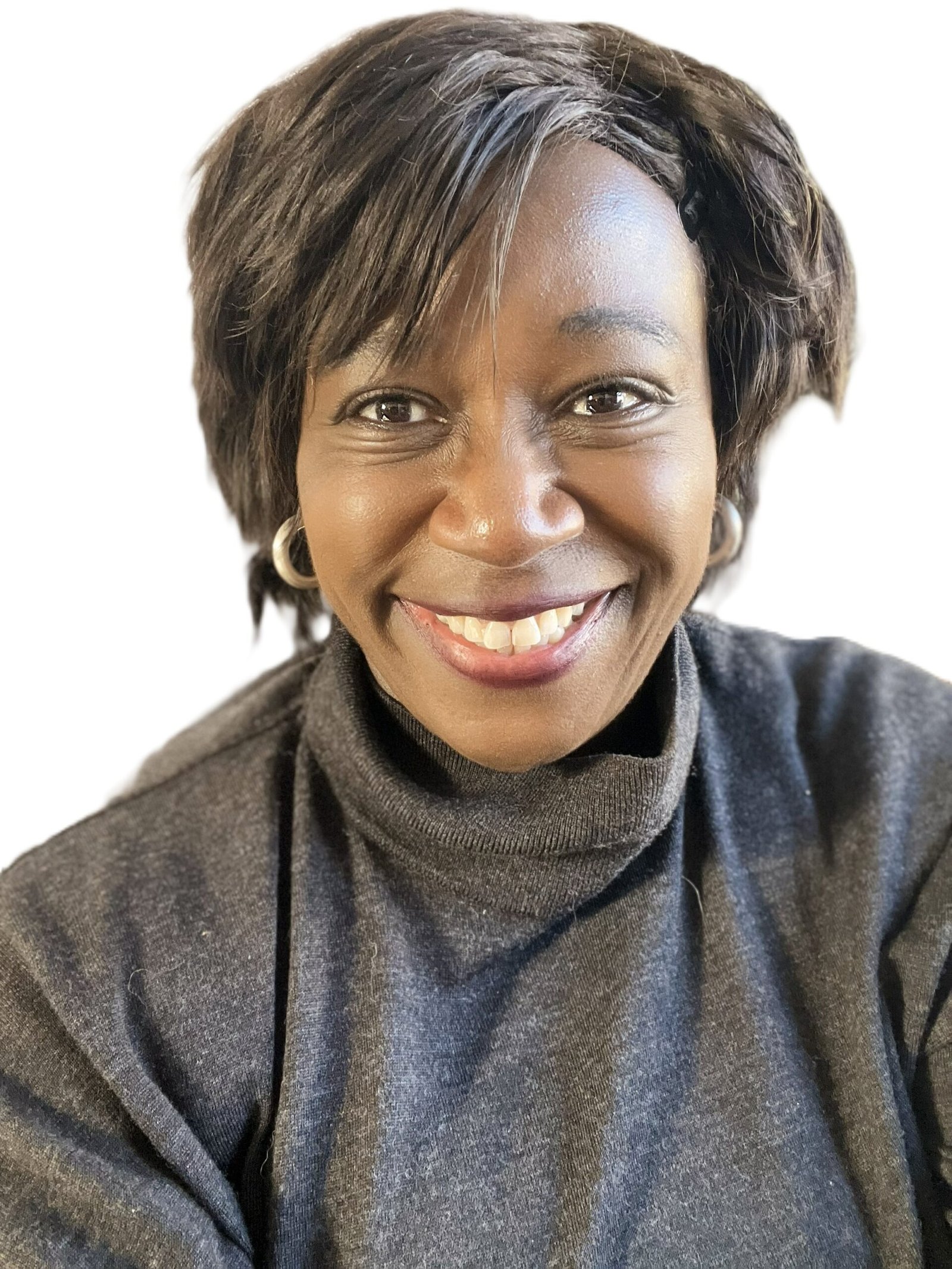 A Black woman smiling at the camera. She is wearing a grey polo neck jumper